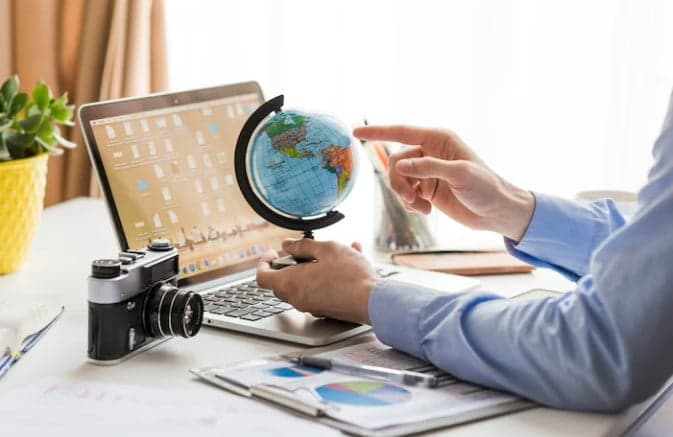 Student planning education abroad with globe and laptop